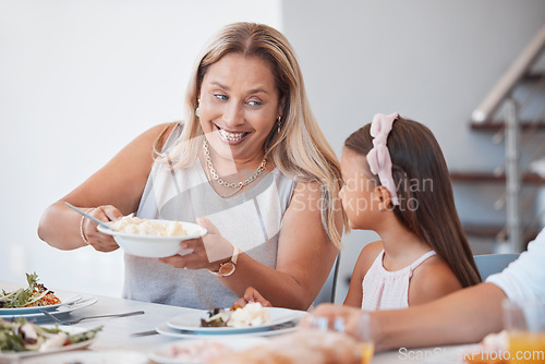 Image of Happy, lunch and grandmother with child at the table eating a meal together with their family. Happiness, conversation and senior woman talking, eating and bonding at dinner, party or event at a home