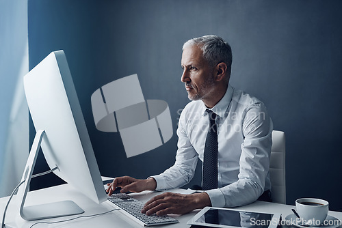 Image of Typing accountant, computer and elderly man in studio, working and isolated on a dark background mockup. Focus, writing or serious executive at desktop for reading email, research or business auditor