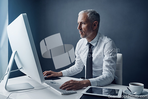 Image of Typing auditor, computer and elderly man in studio, working and isolated on a dark background mockup. Focus, writing or serious executive at desktop for reading email, research or business accountant