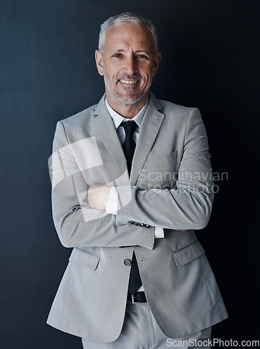 Image of Portrait of confident, mature lawyer with suit, smile and arms crossed on dark background in studio. Happy, professional and executive attorney ceo or senior business owner at law firm with pride.