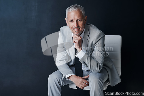 Image of Portrait of senior lawyer on chair with smile, confidence and mockup space on dark background in studio. Pride, professional career and happy executive attorney mature businessman or law firm boss.