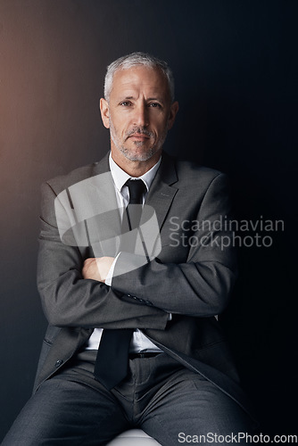 Image of Portrait, chair and serious businessman with confidence, lawyer or attorney with on dark background in studio. Boss, ceo and professional business owner, senior director at law firm with arms crossed