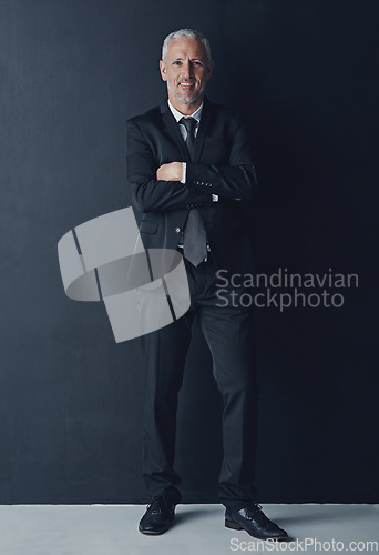 Image of Studio portrait of mature businessman in suit, arms crossed and smile on dark background. Confidence, pride and professional career for happy executive man or senior business owner or successful ceo