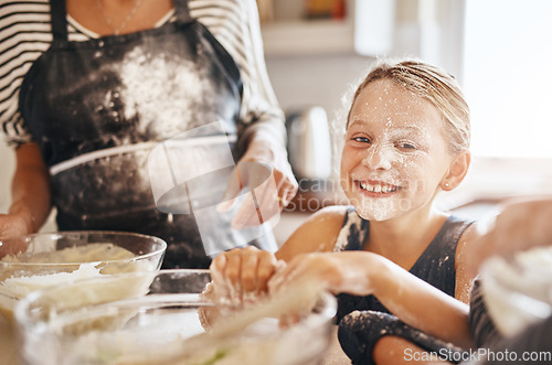 Image of Flour, playing or portrait of girl baking in kitchen with a messy young kid smiling with a dirty face at home. Smile, happy or parent cooking or teaching a fun daughter to bake for child development
