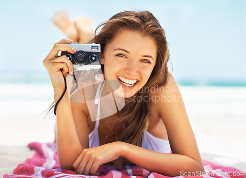 Image of Portrait, camera and a woman tourist on the beach during summer for a holiday or luxury vacation. Ocean, bikini and smile with a happy young female photographer on the sand to relax by a coastal sea