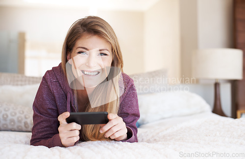 Image of Teenager, girl in portrait and smartphone with games and relax in bedroom, smile with technology and esports. Young female person at home, gaming and mobile app with happiness, gen z and internet