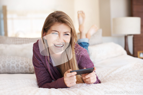 Image of Teenager, happy and girl with games, using phone and relax in bedroom, smile with technology and esports. Young female person at home, gaming and mobile app with happiness, gen z and internet