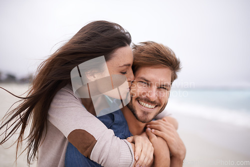 Image of Woman kiss man, happiness and beach with holiday, travel and love with care and trust outdoor. Freedom, affection and fun with couple in nature, vacation and smile with support and hug by the ocean