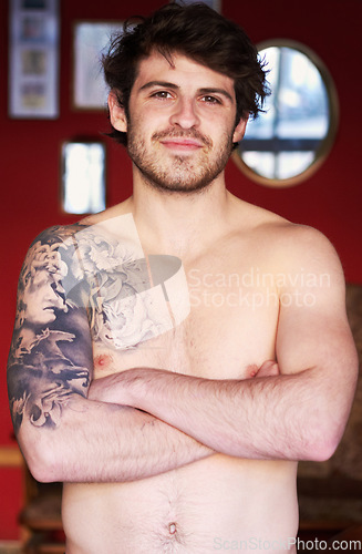 Image of Happy, tattoo and portrait of a man with arms crossed for creativity, punk aesthetic and unique. Smile, morning and a person with pride, confidence and topless in a house with edgy style and body art
