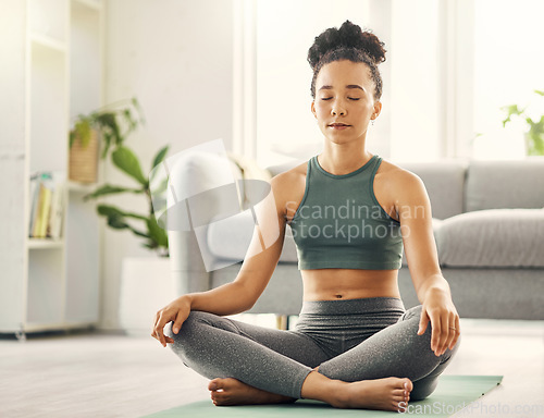 Image of Meditation, woman and lotus pose on living room floor for peace, mental health and wellness at home. Yoga, breathing and exercise by female meditating in a lounge for zen, holistic or chakra training