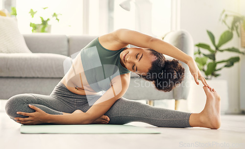 Image of Yoga, stretching and woman on a living room floor for training, exercise or mental health at home. Leg, stretch and female with flexible fitness or pilates workout for balance, meditation or wellness