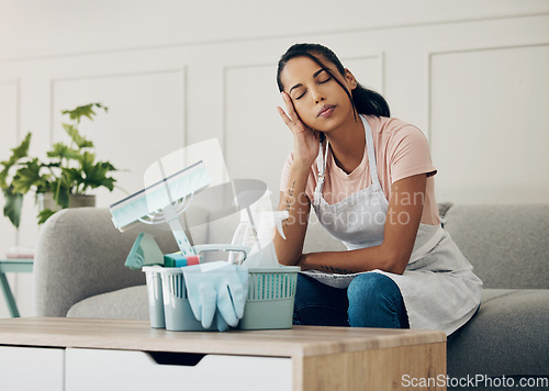 Image of Cleaning, tired and exhausted woman in a house to clean with supplies, detergents or tools. Young female or cleaner in a lounge with headache or stress in an apartment or room with fatigue or problem