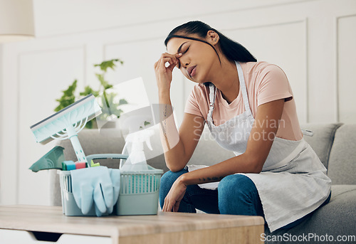 Image of Tired, exhausted and woman cleaning a house with supplies, chemical or tools. Young female or cleaner in a clean lounge with headache or stress at an apartment or room with fatigue or problem