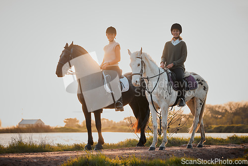 Image of Horse riding, sunset and hobby with friends in nature on horseback by the lake during a summer morning. Countryside, equestrian and female riders outdoor together for travel, hobby or adventure