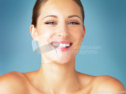 Image of Smile, cosmetics and portrait of happy woman with dermatology, skincare and makeup on blue background. Happiness, skin care and wellness, face of model with beauty and facial glow on studio backdrop.