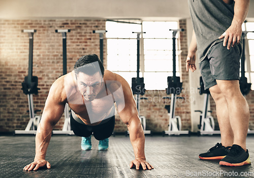 Image of Push up, training and man or personal trainer in gym support, motivation and helping body builder in fitness. Muscle, strong and focus of people exercise or workout on floor, advice or accountability
