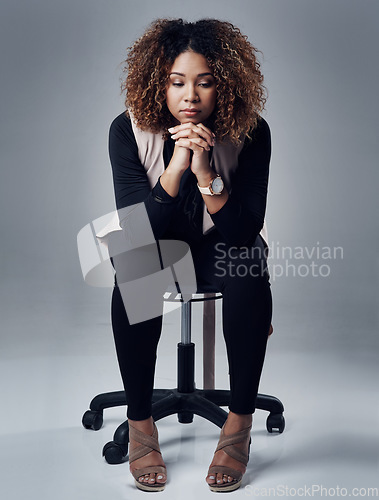 Image of Thinking, depression and young woman in studio with sorrow, grief or mental health problems. Sad, stress and female person contemplating with frustration sitting on chair isolated by gray background.