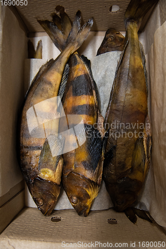 Image of Smoked rock trout fish in craft paper box.