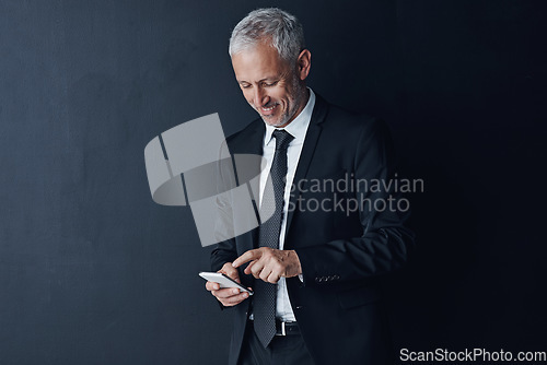 Image of Business, ceo and mature man with a smartphone, connection and contact on a dark studio background. Male person, employee and consultant with a cellphone, mobile app and network with online reading