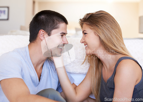 Image of Love, smile and couple relax and bond on a sofa with care, sweet and touching face in their home together. Intimacy, romance and woman with man in a living room happy, chilling and enjoy relationship