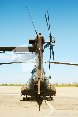 Image of Military, camouflage and a helicopter landing at a special forces base outdoor for army transportation. Aircraft, vehicle or air transport with a chopper ready for war, combat or defense outside
