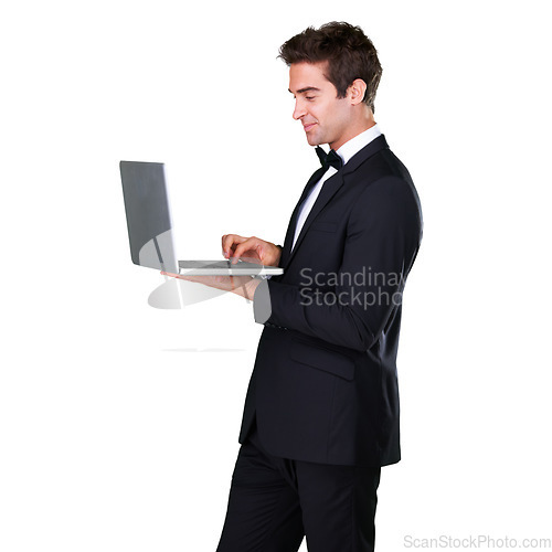 Image of Male waiter, typing and laptop with service and suit in white background is working at restaurant. Butler, bowtie and technology with man in hospitality with tuxedo, luxury and menu in studio.