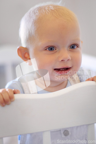 Image of Happy, children and baby in the crib of a nursery in his home for growth, child development or curiosity. Kids, bedroom and toddler with a male or boy infant standing in his cot looking adorable