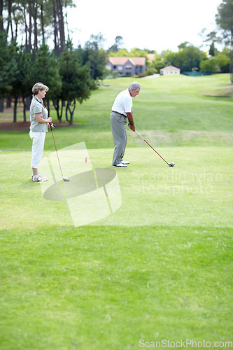 Image of Old couple, sports or golfer playing golf for fitness, workout or exercise to swing on a course or field. Senior woman, elderly man golfing or training in practice game and driving with a club stroke