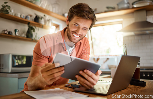 Image of Technology, happy man with tablet and laptop for remote work in kitchen of his home with a lens flare. Social networking or connectivity, online communication and male person smile for email