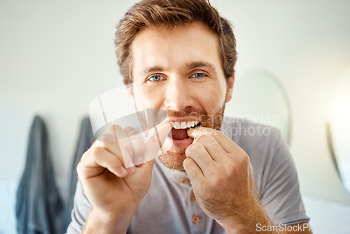 Image of Teeth, dental floss and portrait of man in bathroom for self care, oral hygiene and morning routine. Cleaning, smile and health with face of male person at home for beauty, wellness and results