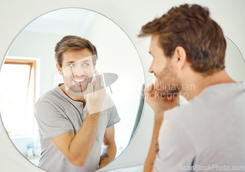 Image of Bathroom, mirror and happy man with skincare cream for self care, skin hydration or home beauty treatment. Face cosmetics, dermatology smile or reflection of person with morning sunscreen application