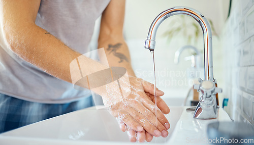 Image of Soap, water and man washing hands at tap for skincare, healthy dermatology and safety of bacteria at home. Closeup, person and cleaning palm with foam at basin for hygiene routine, wellness or habit