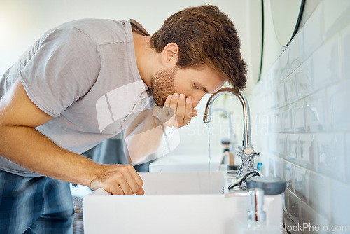 Image of Man in bathroom, mouth wash and water with morning routine, health and wellness in home. Dental care, cleaning teeth and face with male grooming for fresh breath, hygiene and getting ready in house.