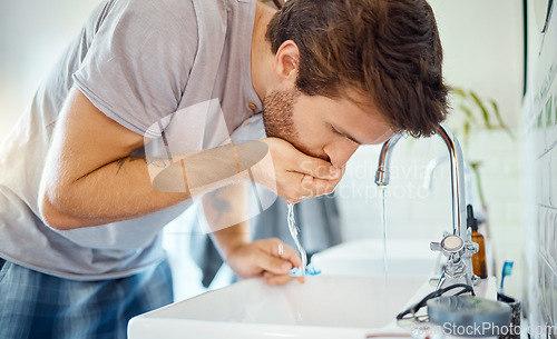 Image of Man in bathroom, brushing teeth and rinse with water, morning cleaning routine for health and wellness in home. Dental care, mouthwash and toothbrush, male grooming for fresh breath and oral hygiene.