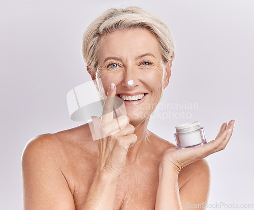 Image of Beauty, cream and senior woman with skincare, dermatology and happy in portrait on white background. Sunscreen, moisturizer and face care, female model apply lotion with glass container and antiaging