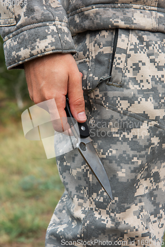 Image of A man with a knife in the forest.