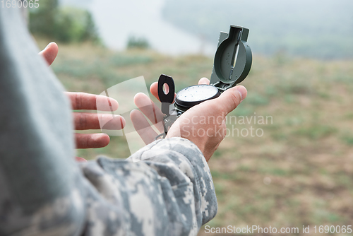 Image of Man with compass in hand outdoor