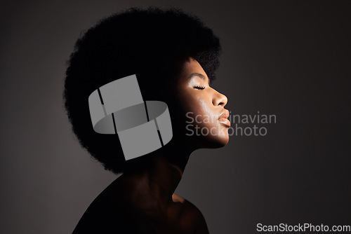 Image of Face shadow, light and black woman with skincare, natural beauty glow and peace after cosmetics treatment. Aesthetic makeup profile, afro and African studio person with self care on grey background