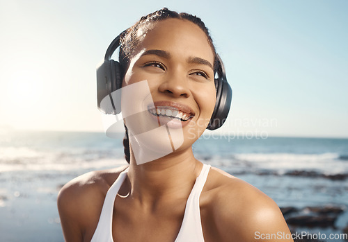 Image of Thinking, headphones and woman at beach fitness, exercise or running mindset, training goals or inspiration music. Health, podcast and athlete, runner or sports person, sea listen and audio streaming