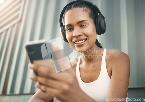 Image of Fitness, phone or happy girl on social media in city listening to music or radio on exercise or running break. Headphones, funny meme or woman athlete runner on mobile app for a fun workout tutorial