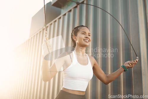 Image of City, jumping rope or happy woman in fitness training, workout or body exercise for cardio outdoors. Girl thinking, active or healthy female sports athlete skipping with smile for wellness in town