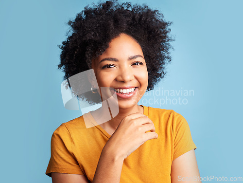Image of Happy, smile and portrait of a woman in a studio with a positive, good and confident mindset. Happiness, excited and headshot of a young female model with an afro from Colombia by a blue background.