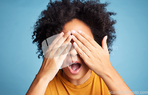 Image of Shock, scared and woman closing her eyes in a studio for fear, horror or panic expression. Surprise, emotion and crazy female model with a cant look gesture or emoji isolated by a blue background.