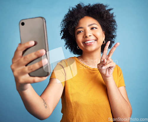 Image of Selfie, peace sign and young woman isolated on blue background for social media or content creation. Gen z, youth and african person or influencer with online profile picture and emoji in studio