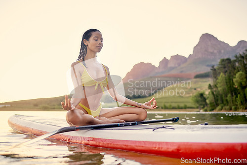 Image of Yoga, surfboard and woman meditation on ocean, fitness and wellness or spiritual, peace and calm in bikini. Surfing board, balance and person meditate, lotus hands and holistic training in nature