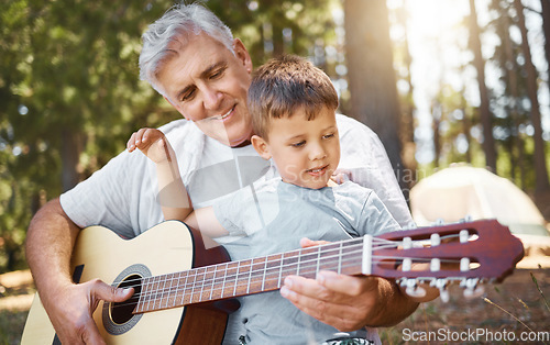 Image of Senior man, boy and camping with guitar, music and teaching with freedom, smile or outdoor in summer. Grandfather, instrument and male child in forest, learning and retirement on vacation in nature