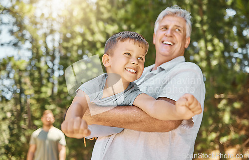 Image of Hiking, family and a boy flying with his grandfather outdoor in nature while camping in the forest or woods. Love, fun and a young male child playing with his senior grandparent in the wilderness