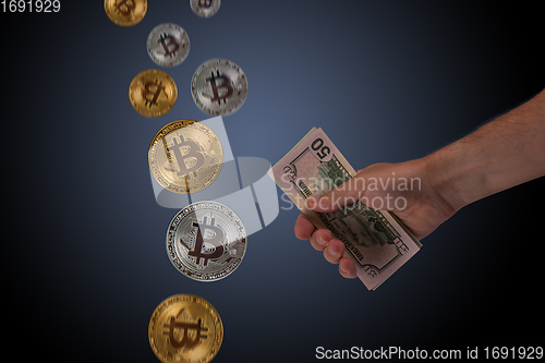 Image of Hand holding dollar money and bitcoin on blue dark background