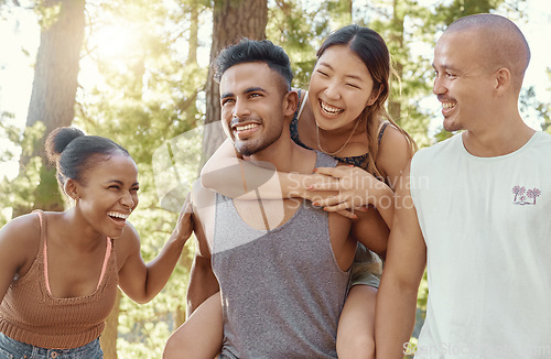 Image of Happy friends, laughing and piggyback in forest for fun holiday, weekend or vacation in the nature outdoors. Men and women enjoying funny time together in friendship on camping trip or walk in woods