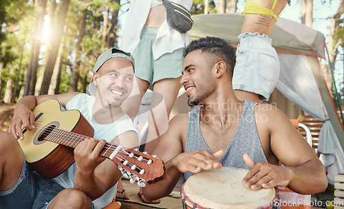 Image of Musician, friends and playing music with guitar and drum on a summer camping, holiday in the woods, forest or nature. Men, happiness and people together for musical performance, song or band